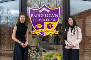 Evelyn Riley and Kate Sharp stand in front of Bardstown High School