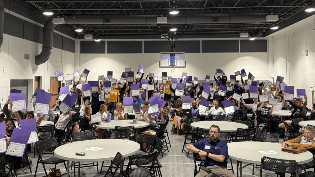 group picture in Polytech Center holding up purple folders